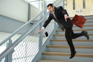 Businessman fall off the stairs going to parking lot.