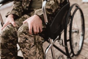 Veteran in a Wheel Chair Gripping His Leg