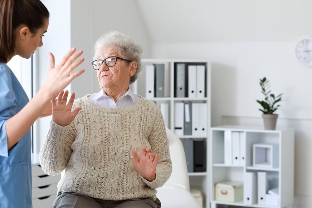 Terrified elder woman from caretaker at nursing home care.