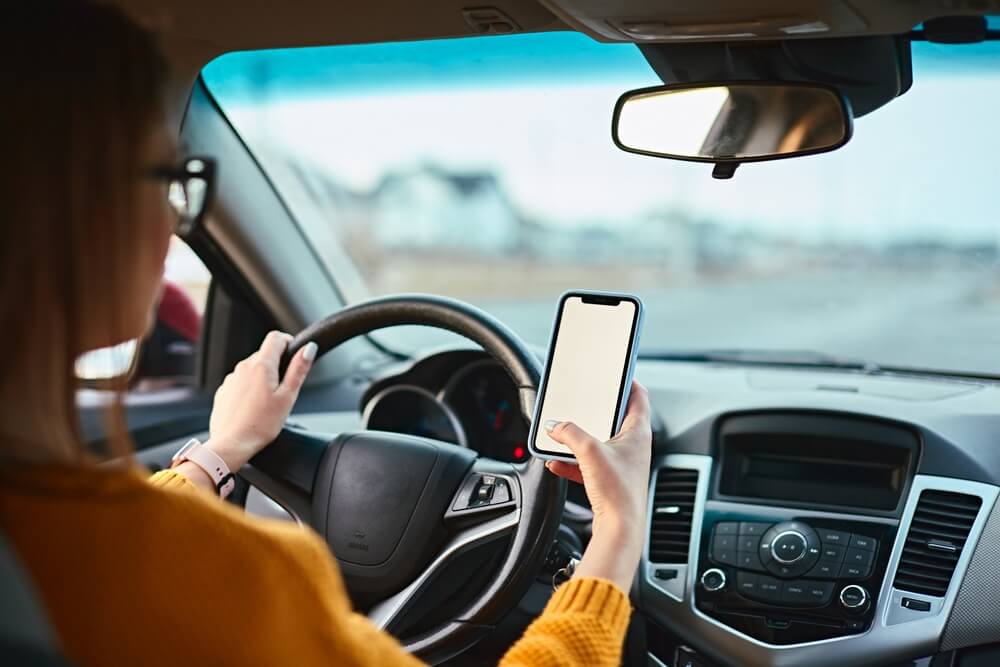 Lady driver using her mobile phone.