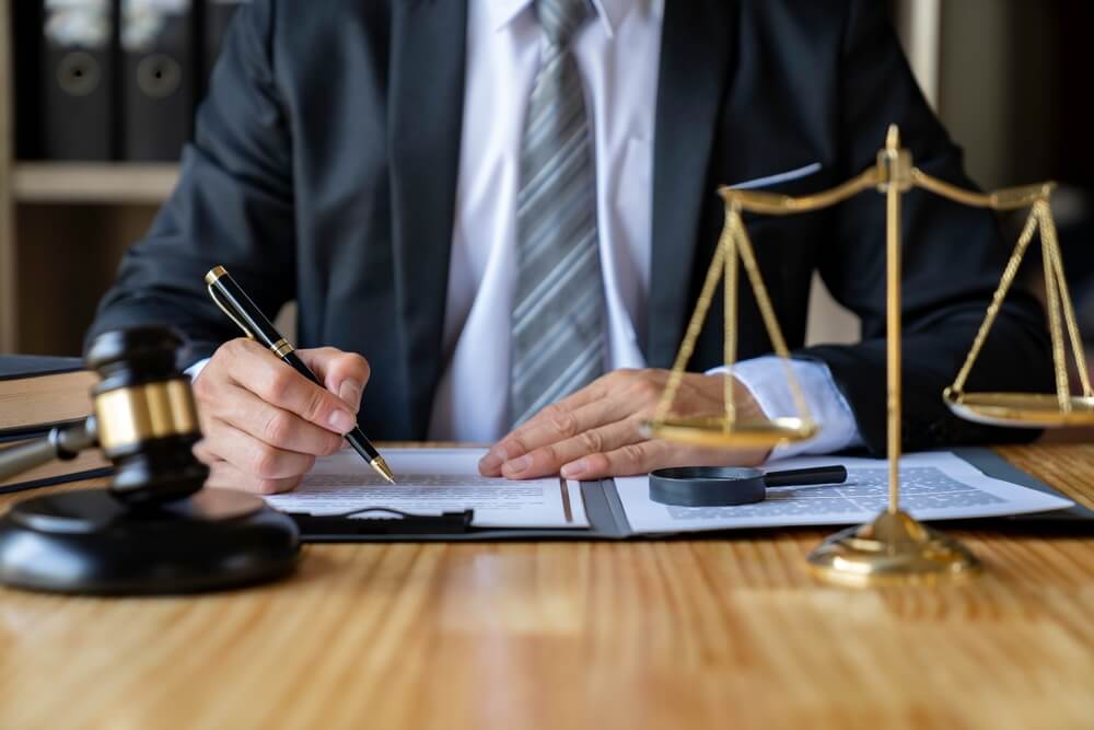 Lawyer signing doc in his law office.