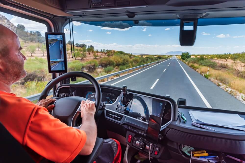 Truck driver driving on a straight highway.