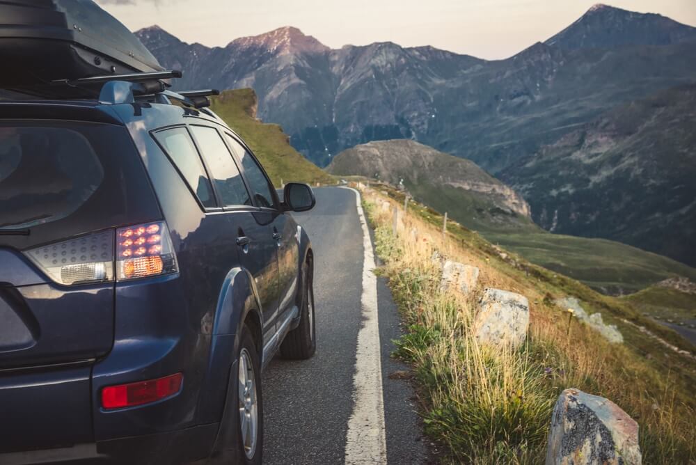 SUV driving uphill with mountain scenery